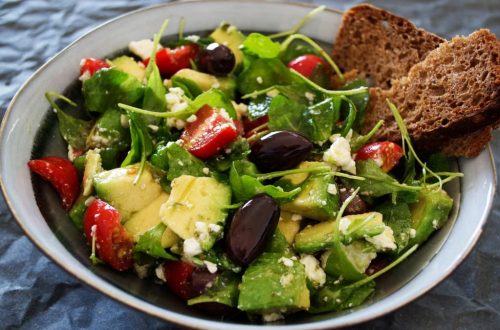 Delicious Greek salad featuring avocado, feta, and olives, ideal for a healthy meal.